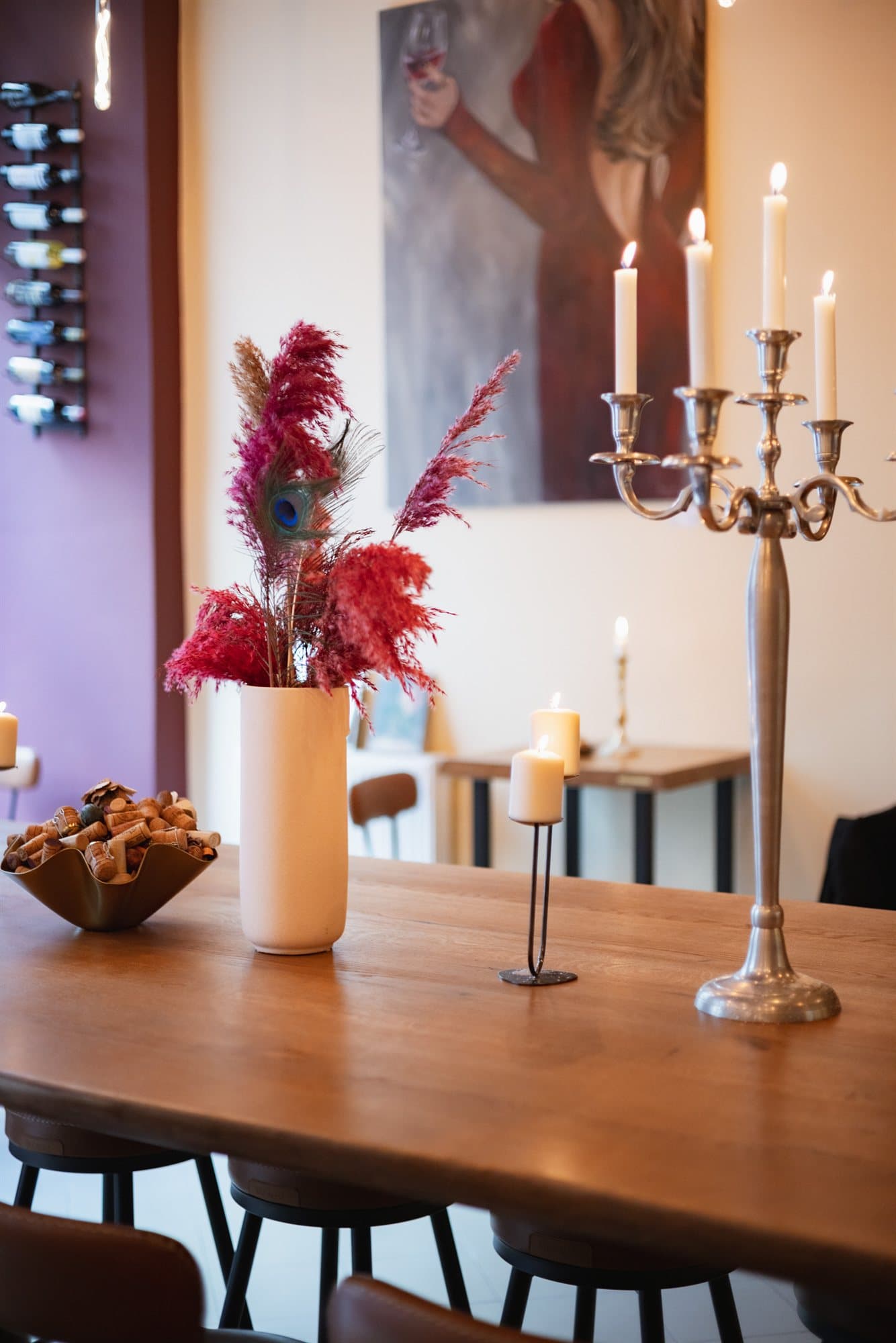 A candlelit table set with a silver candelabra and dried florals